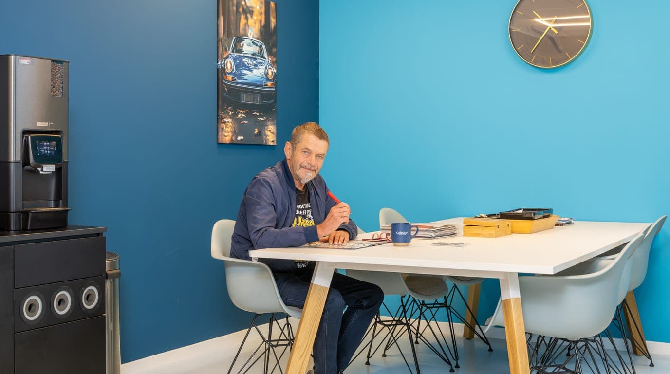 Twee mensen overleggen aan tafel in de blauwe ontvangstruimte