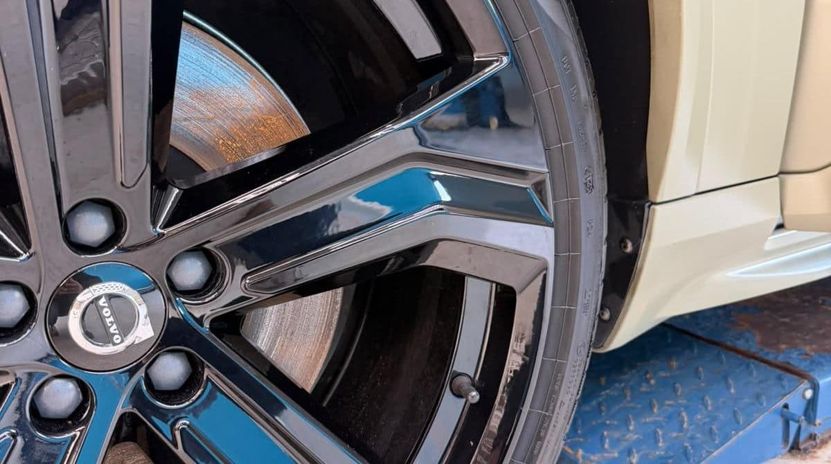 Close-up van een schone, glanzende zwarte velg aan een auto in de werkplaats